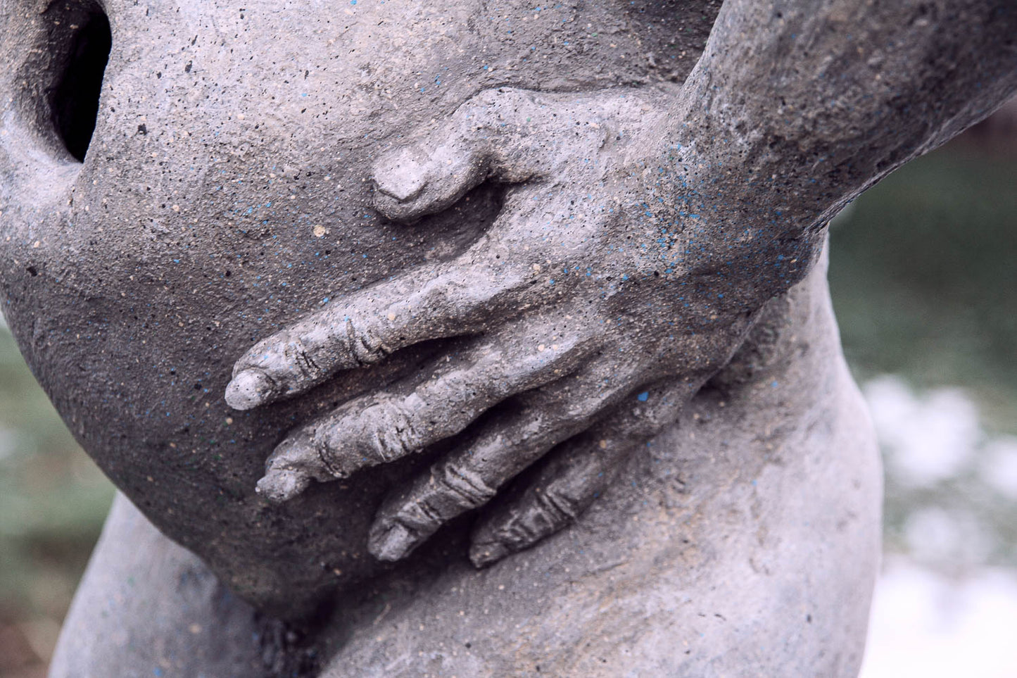 detailanischt der linken hand am schwangeren dicken bauch der beton katzenfrau