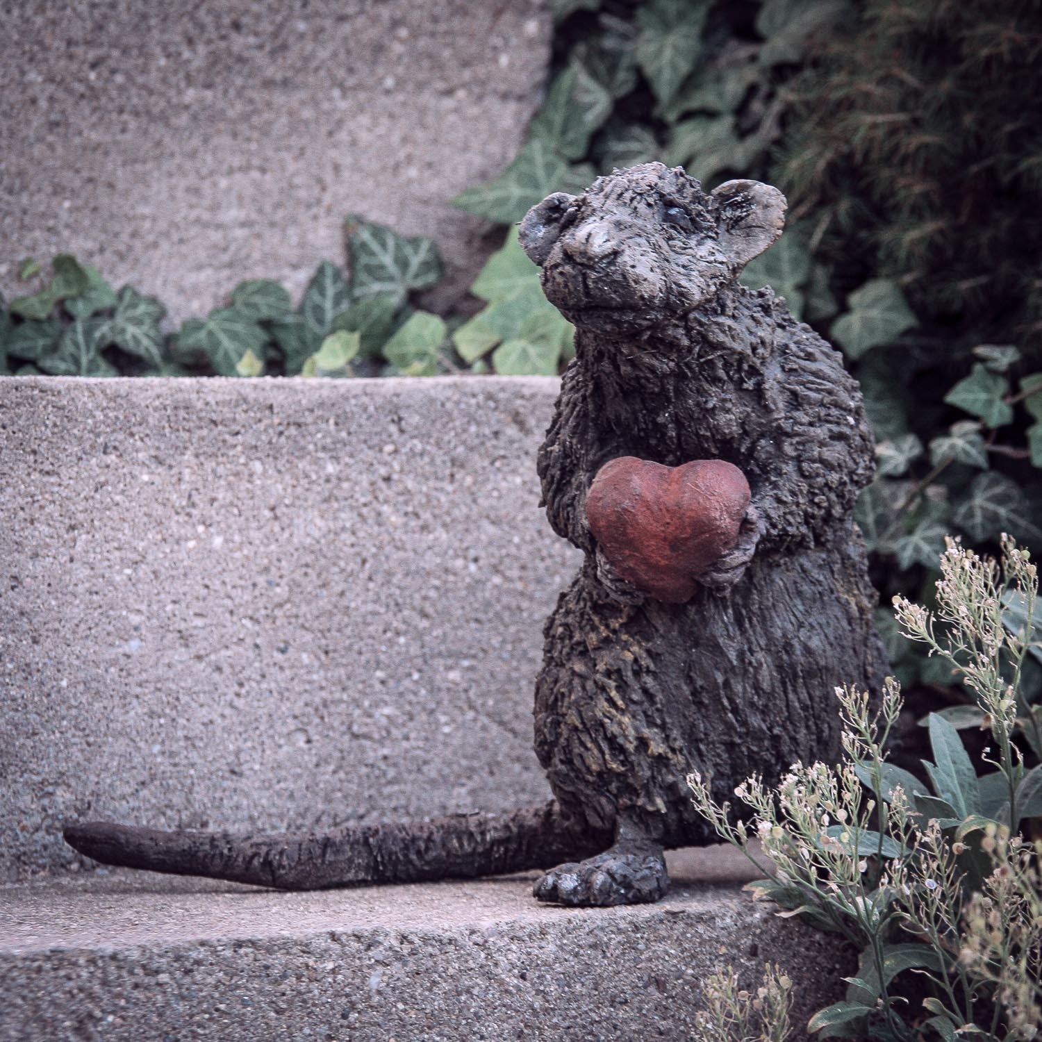 kleien Ratte aus beton mit rotem herz in den kleinen Händchen