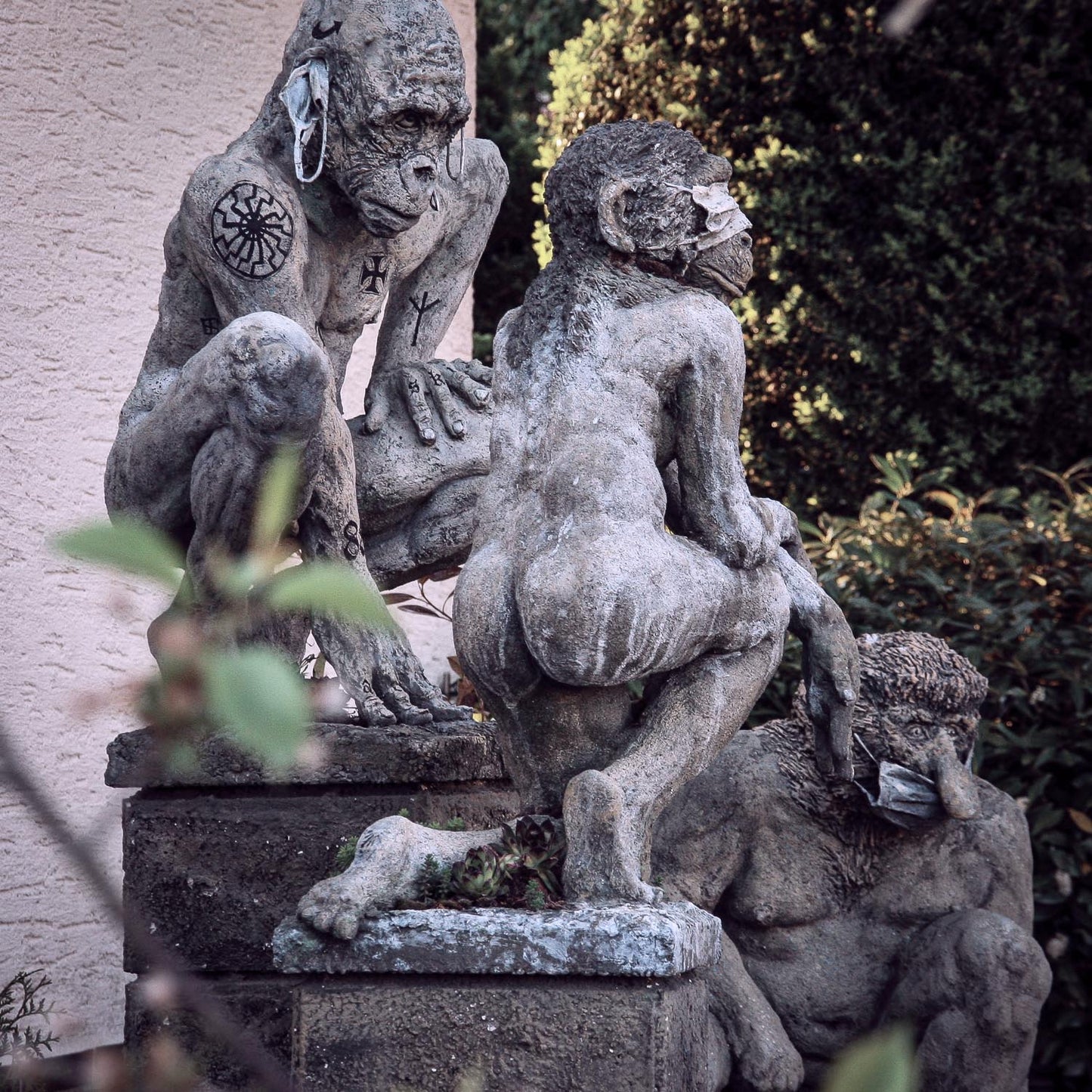 seitliche ansicht auf covidioten skulpturen gruppe aus beton, die an die drei affen -nichts sehen, nichts hören, nichts sagen erinnern