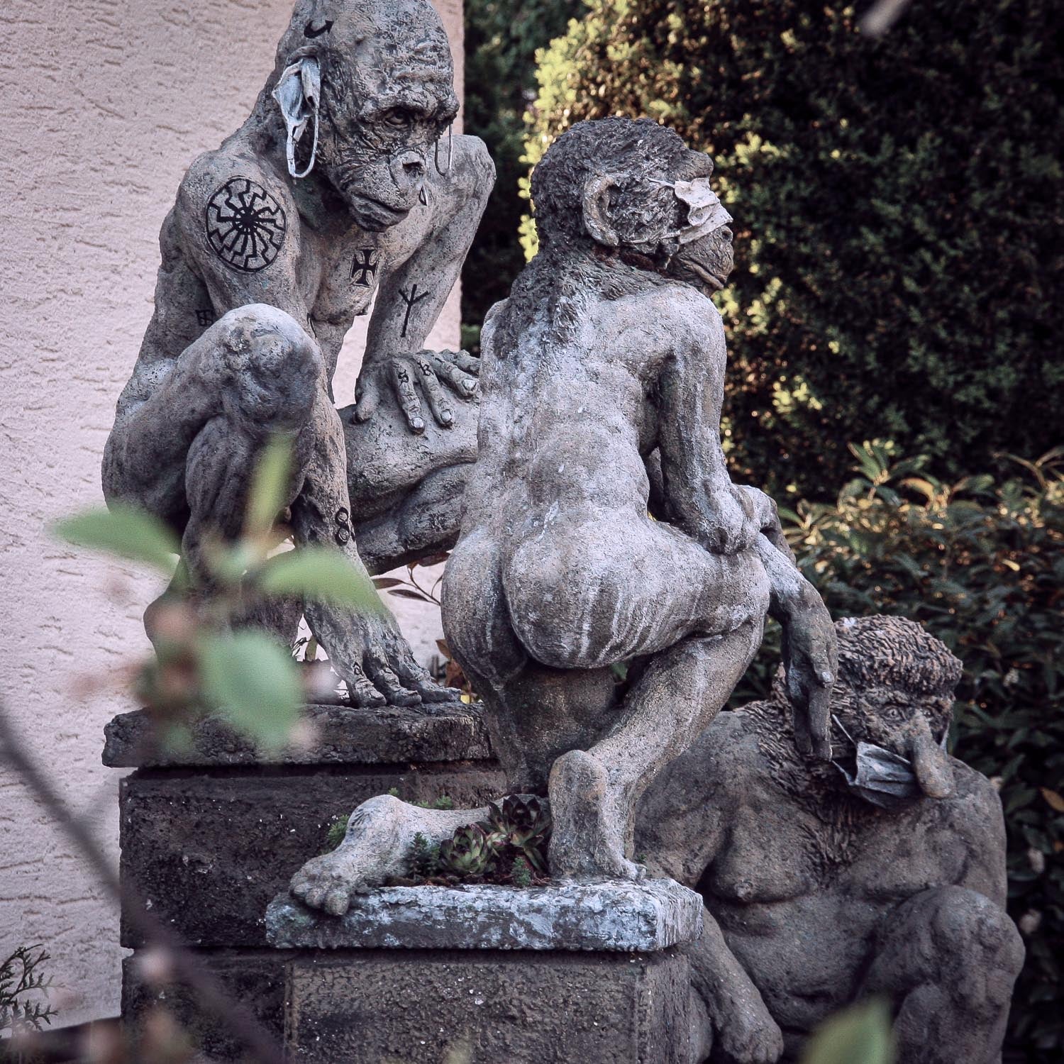seitliche ansicht auf covidioten skulpturen gruppe aus beton, die an die drei affen -nichts sehen, nichts hören, nichts sagen erinnern