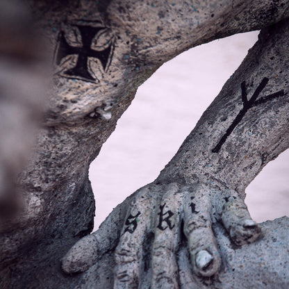 linke betonhand von ronny, auf die SKIN tätowiert ist, ber der brust ein eisernes kreuz und ein rune auf dem unterarm