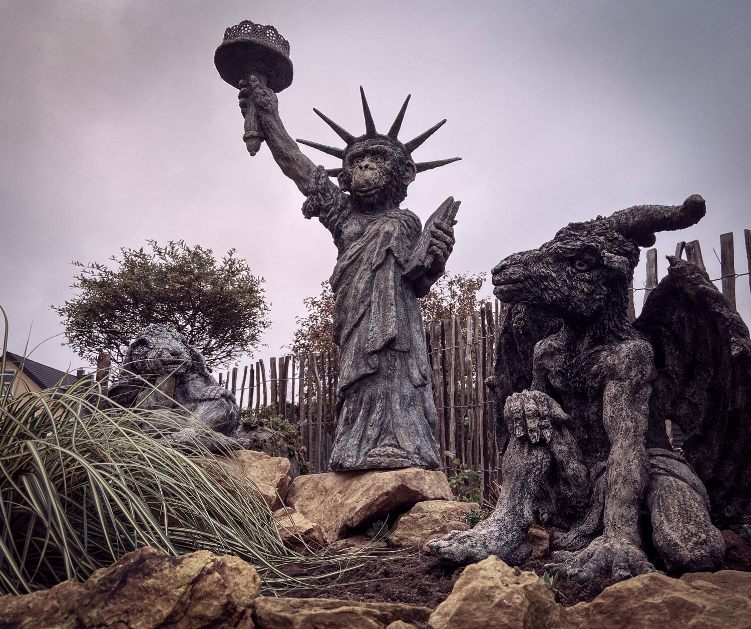 affe als kleine freiheitsstatue flankiert von Schäfchen und Ziegenbock