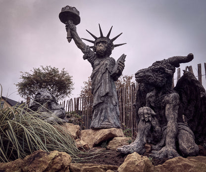 affe als kleine freiheitsstatue flankiert von Schäfchen und Ziegenbock