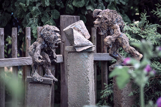 zwei menschliche paviane als kleine beton skulpturen gehen aufeinander los und drohen und schreien sich an wegen der letzten klopapierrolle